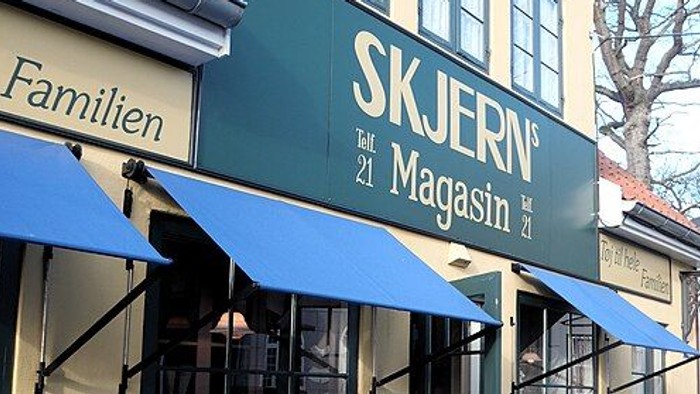 Butiksfacade med blå markiser og skiltning