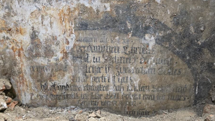 Alter Stein mit verblasster Inschrift, teilweise erodiert.