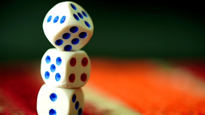 Drei weiße Würfel auf einer roten Oberfläche gestapelt.