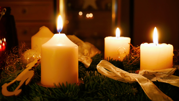 Drei brennende Kerzen auf Weihnachtsdekoration