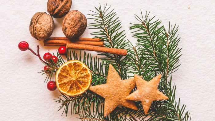 En festlig udsmykning med nødder, kanelstænger, tørret appelsin, stjerner og grønne grenar