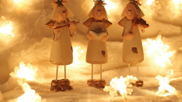 Drei Engelfiguren im Lichterglanz