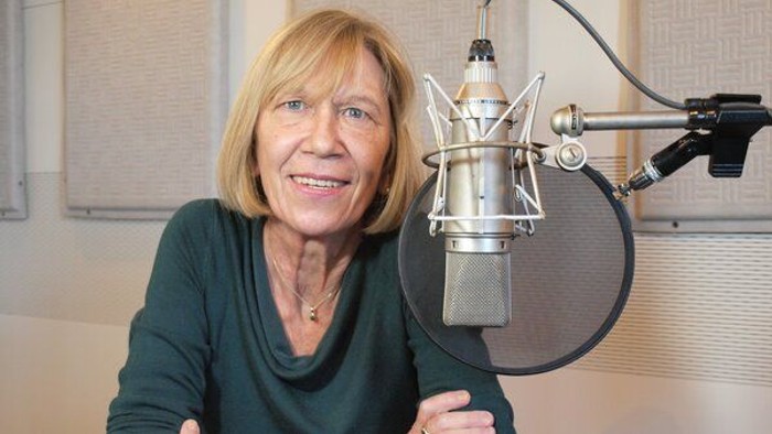 Lächelnde Frau neben einem Mikrofon.