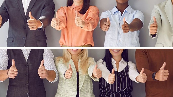 Menschen, die in verschiedener Geschäftskleidung Daumen hoch zeigen.