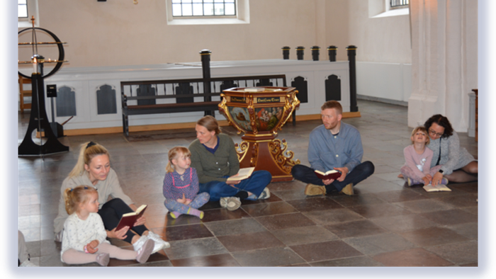 Familie, der læser sammen i et stort rum.