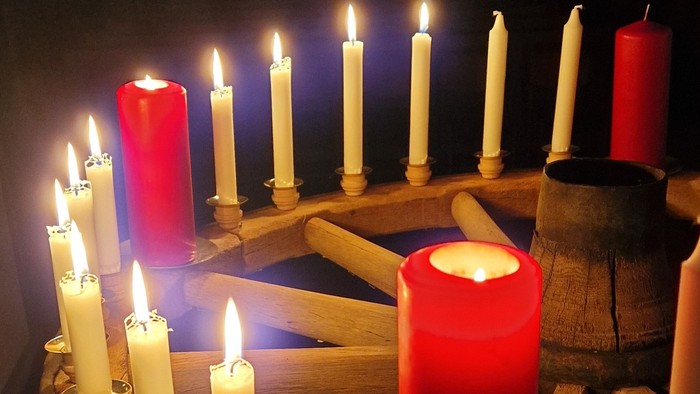 Brennende Kerzen auf einem alten Wagenrad.