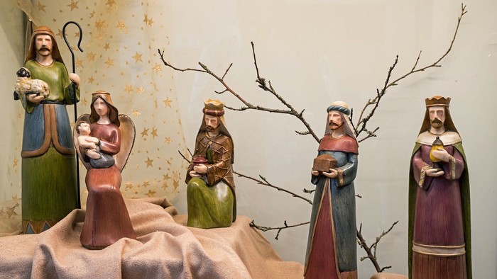 Fünf Figurinen, die eine religiöse Szene darstellen, wahrscheinlich die Weihnachtskrippe, wobei eine ein Baby hält.