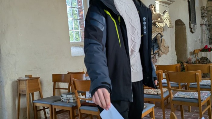 Ein Jugendlicher steckt seinen Stimmzettel in die Wahlurne.