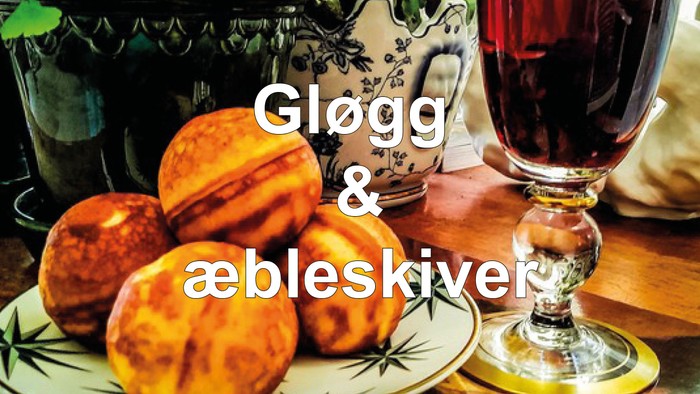 En tallerken med runde bagværk og et glas rødvin på et bord.