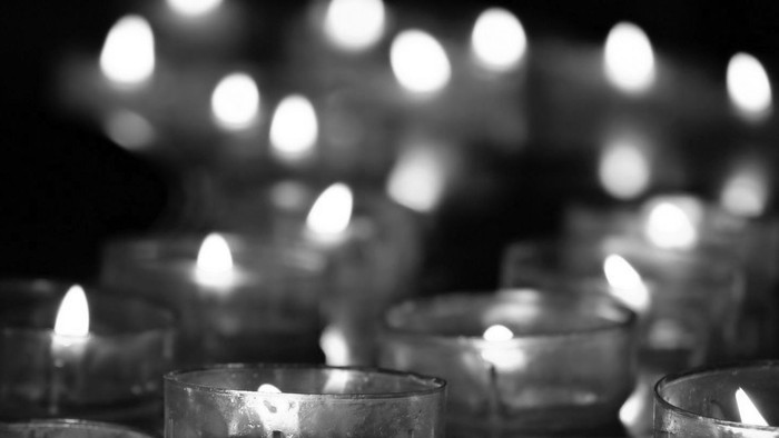 Mehrere brennende Kerzen in Gläsern, unscharfes Hintergrundlicht