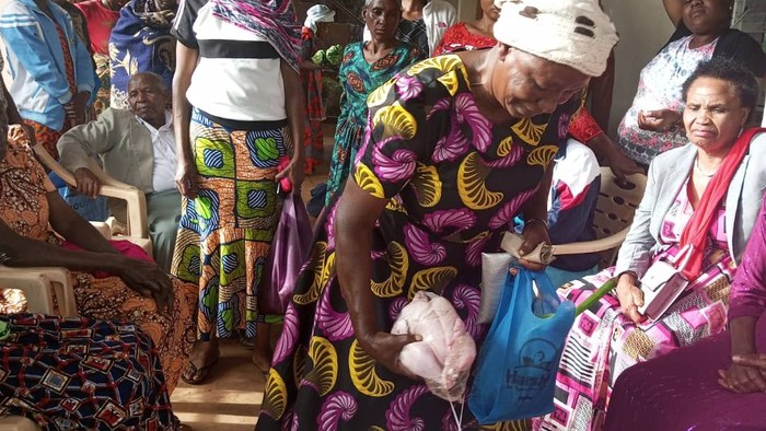 Eine Gruppe von Frauen sitzt in einem Raum, eine Frau hält ein Baby.