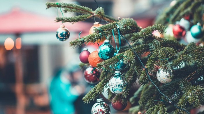 En juletree med pynt med glitrende kugler i røde, grønne og sølv farver.