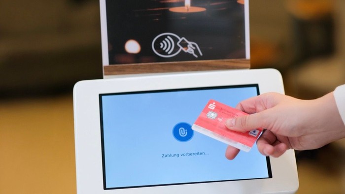 Person zahlt per Kreditkarte an Tablet