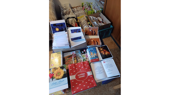 Verschiedene Gegenstände wie Bücher, Taschen und Kisten sind auf einem Tisch angeordnet.