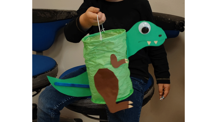 Person, die ein grünes schildkrötenförmiges Objekt mit einem Stock hält