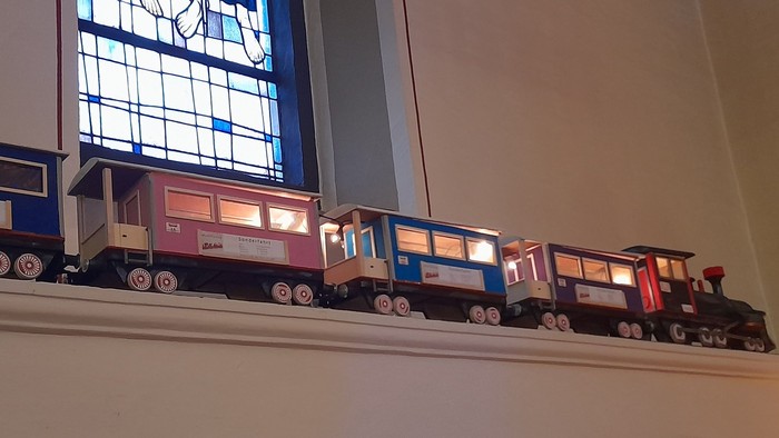 Ein buntes Spielzeugeisenbahn-Set, das auf einem Regal ausgestellt ist.