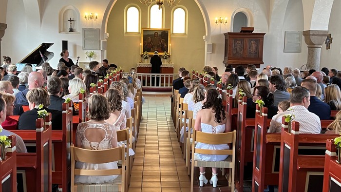 En kirkefuld med mennesker under en ceremoni.