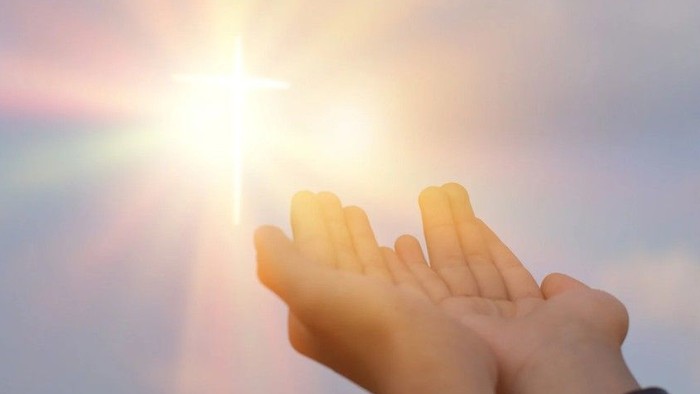 Hände, die nach hellem Sonnenlicht am Himmel greifen