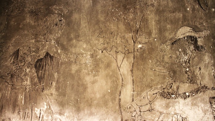 Joseph hat das Jesuskind auf dem Arm. es streckt seine Arme aus, Maria entgegen, die hinter einem Baum hervor kommt. Ein Esel steht vor Joseph und Jesus. Zwischen beiden eine Palme.