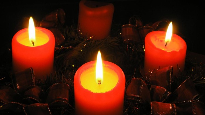 Vier brennende Kerzen in der Dunkelheit