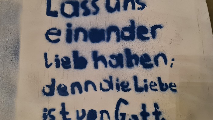 Bibelvers auf der Sitzfläche eines Stuhls im Foyer der Friedenskirche Offenbach: 