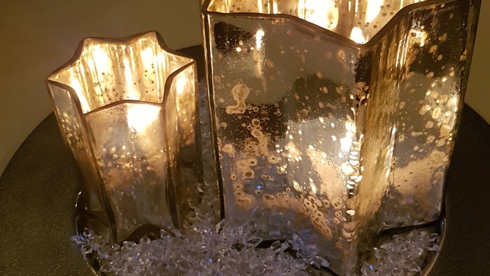 Zwei beleuchtete Sternvasen auf grünem Tablett