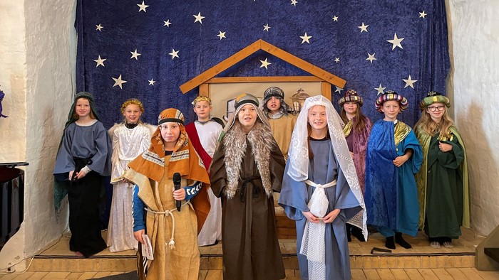 En gruppe skuespillere i juleopførelse forestiller nativity-scenen