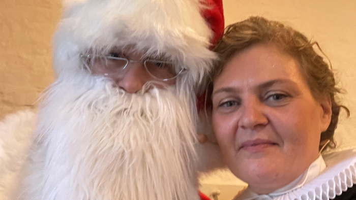 Julemanden poser med smilende kvinde i historisk kostume.