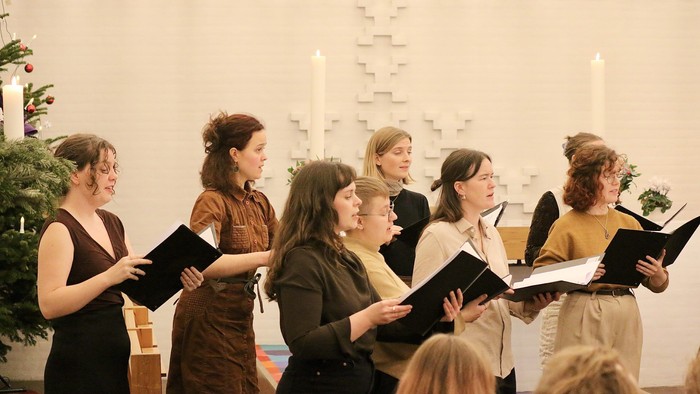 En gruppe kvinder synger i kor i en kirke.