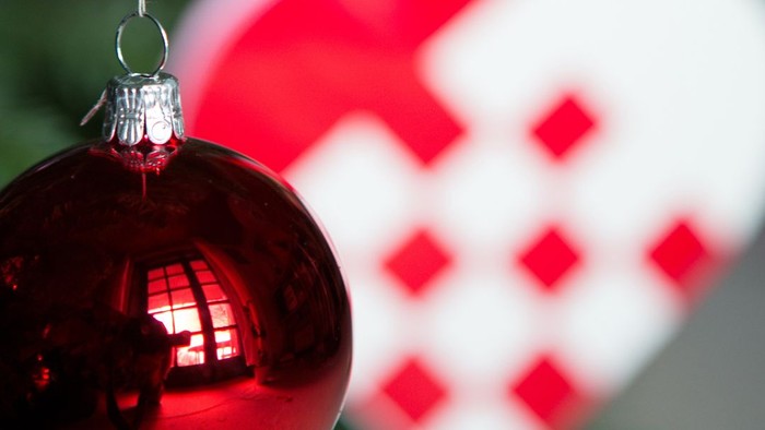 En rød glaskugle hænger på en juletræ.