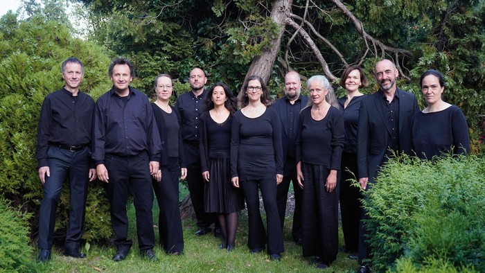 Gruppe von Menschen in schwarzer Kleidung, die im Freien posieren.
