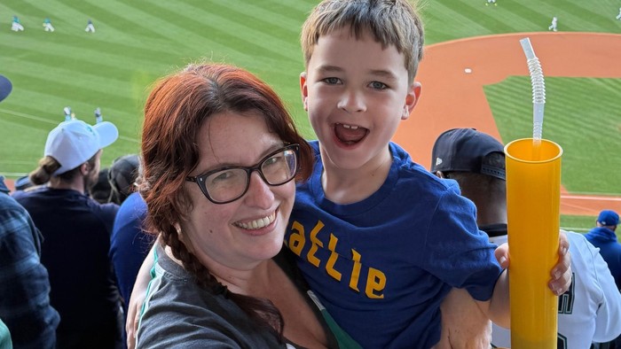 Kristin holding Isaac at a baseball game