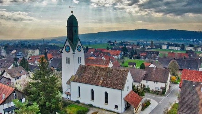 Kirchliche Dorfansicht bei bewölktem Himmel