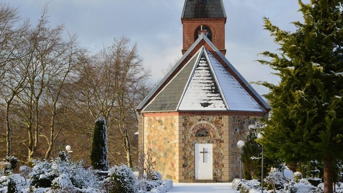 En lille kirke med tårn i sneklædt landskab