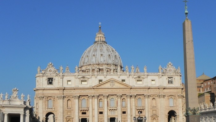 Bild der Fassade des Petersdoms in Rom mit Sonnenschein und blauem Himmel