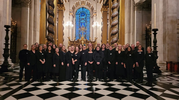 Ein Chor steht in einer prächtigen Kirche und posiert für ein Gruppenfoto.