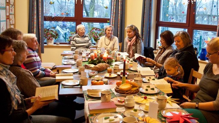Eine Gruppe von Menschen sitzt an einem Tisch und isst gemeinsam.