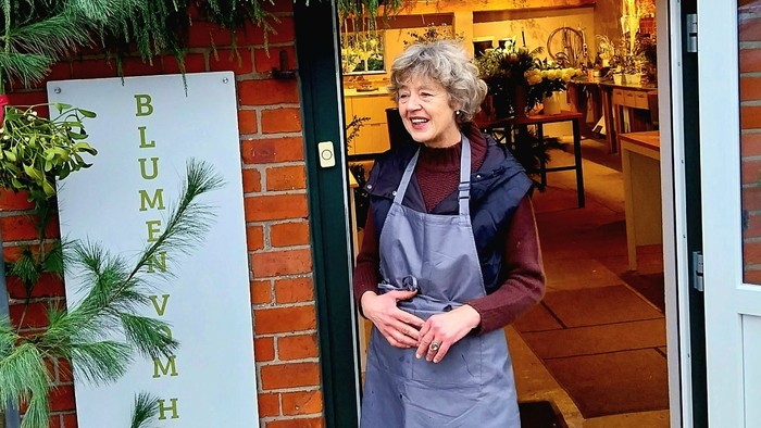 Frau in Schürze, die vor einem Restaurant steht