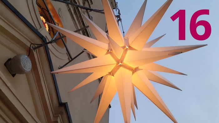 Leuchtender Adventsstern über dem Eingang der Dorfkirche Stülpe und die Zahl 16.