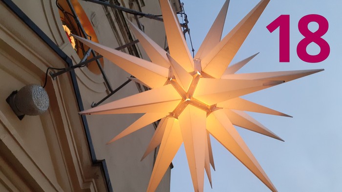 Leuchtender Adventsstern an der Dorfkirche Stülpe und die Zahl 18.