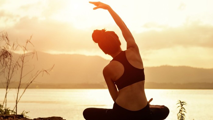 Plakat für eine Veranstaltung zur Stärkung von Frauen, mit einer Frau, die Yoga am See macht