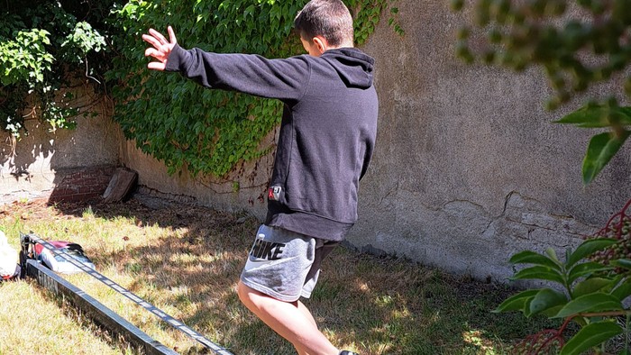 Mann, der auf einem Balken in einem Park balanciert.