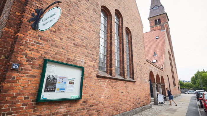 Røde mursten og tårn, skilt og billedskrin på bygning