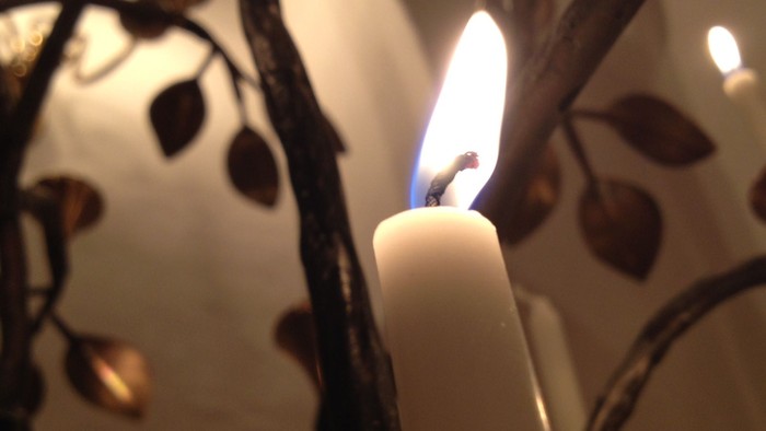 En lysende lyse ståender på en dekoration med blad.