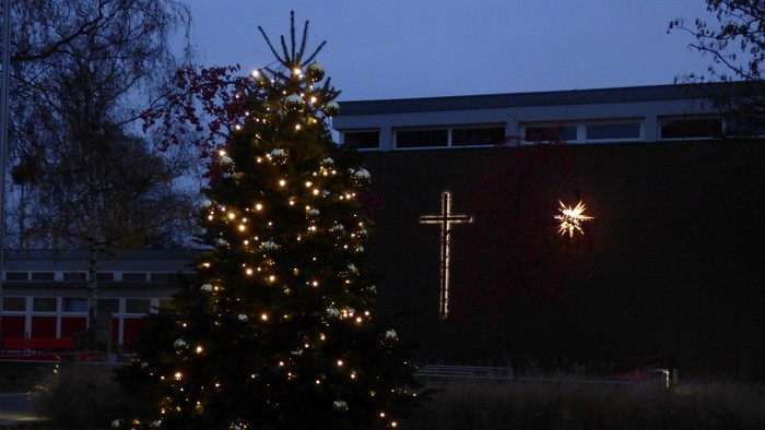 erleuchteter, geschmückter Tannenbaum vor dem Margarete-Draeger-Haus, erleuchtetes Kreuz und Weihnachtsstern an der Fassade