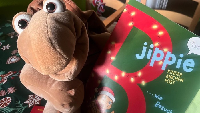 Die Handpuppe Schildkröte Chili hält eine Ausgabe der neuen Kinderkirchenpost in den Pfoten.