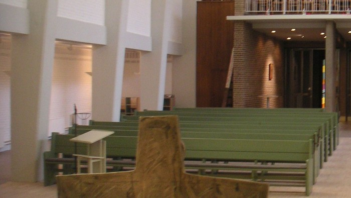 Innenraum einer Kirche mit Kreuz und Kerze