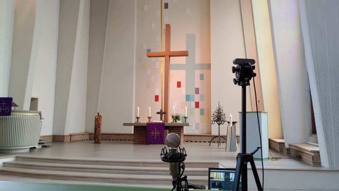 Kirchliche Innenansicht mit Kreuz, Kamera und Statuen