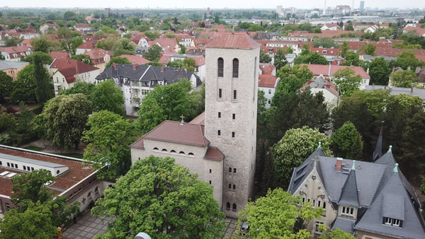 Die Stadtansicht zeigt eine Kirche mit hohem Turm und umgebende Häuser.