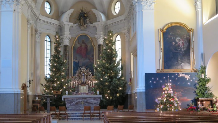 Kirchenraum mit Krippe und Weihnachtsbäumen